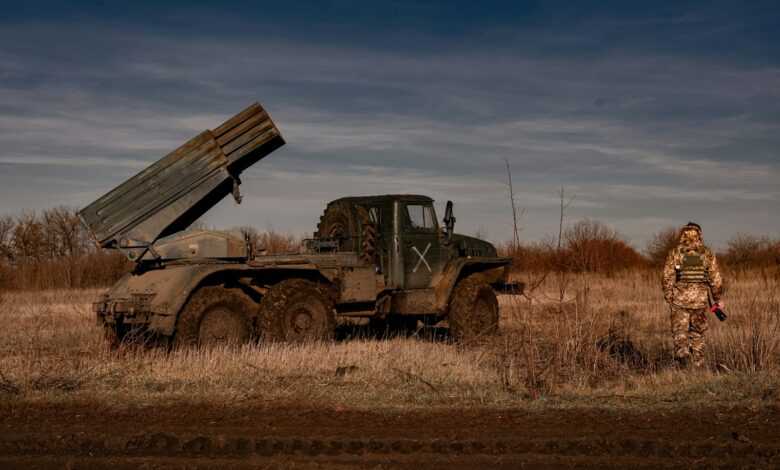 a man standing in a field next to a truck